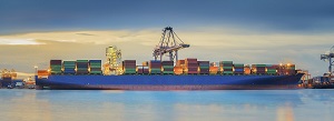 Container Cargo freight ship with working crane loading bridge in shipyard at dusk for Logistic Import Export background
