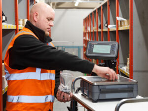 An employee adds to a scale.